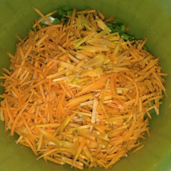 Cuci, kupas dan serut wortel. Cuci dan potong daun bawang.