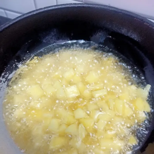 Kupas kentang, cuci lalu potong. Panaskan minyak, goreng sampai setengah kering kemudian sisihkan.
