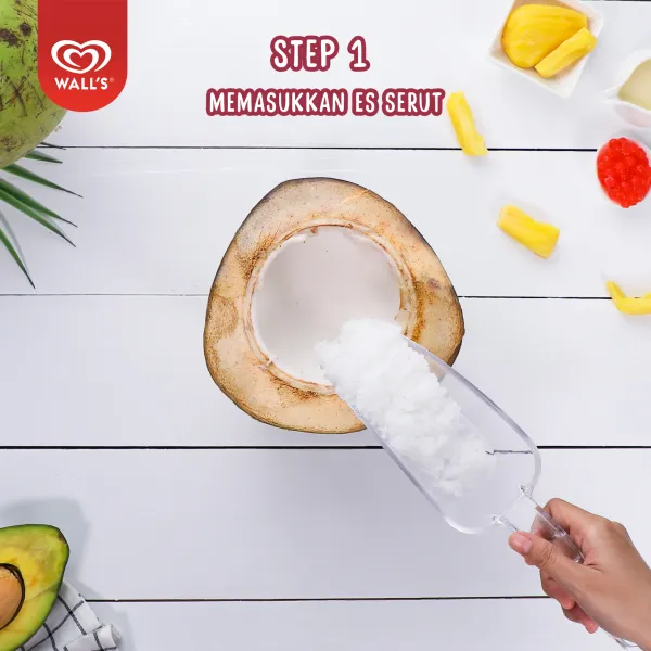 Masukkan es serut ke dalam batok kelapa.