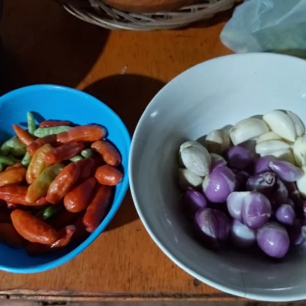 Selagi menunggu ayam melunak, kulas bawang merah dan bawang putih. Bersihkan cabai rawitnya. Cabai rawit sesuai selera ya.