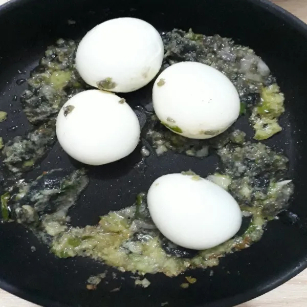 Masukkan telur rebus, aduk sampai bumbu menutupi telur.