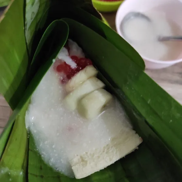 Bungkus daun pisang disalah satu sisi. Kemudian tambahkan kuah santan.