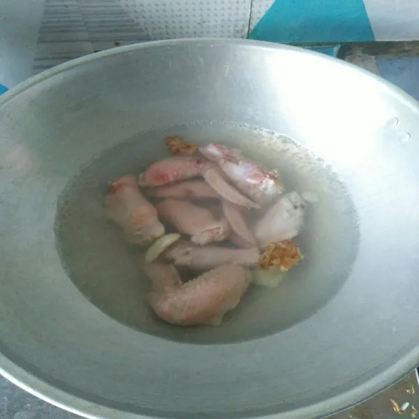 Rebus ayam beserta geprekan bawang putih dan jahe sampai matang