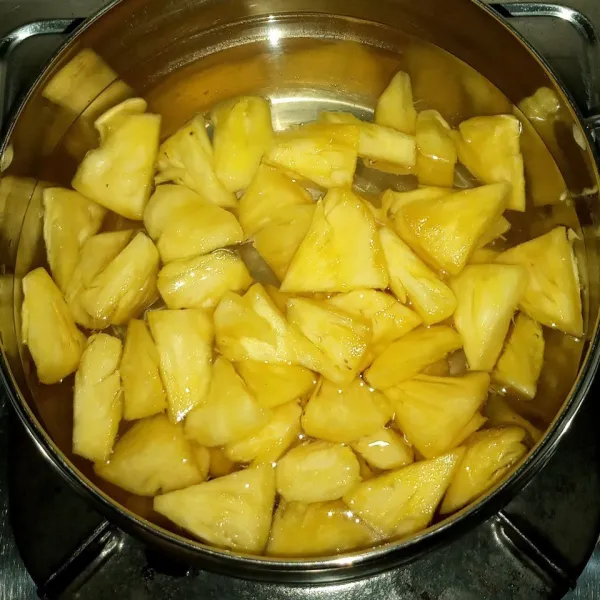 Setelah air gula mendidih, matikan api dan masukkan nanas dan air lemon. Aduk dan biarkan sampai dingin.