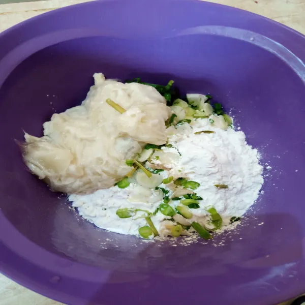 Dalam wadah, siapkan sisa tepung tapioka dan irisan daun bawang. Tambahkan adonan tapioka, campur rata dengan bahan kering