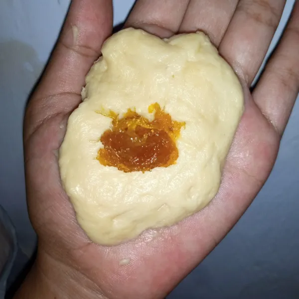 Ambil adonan berat 30gr pipihkan beri isian selai nanas ditengah kemudian tutup rapat letakkan di atas kertas roti.