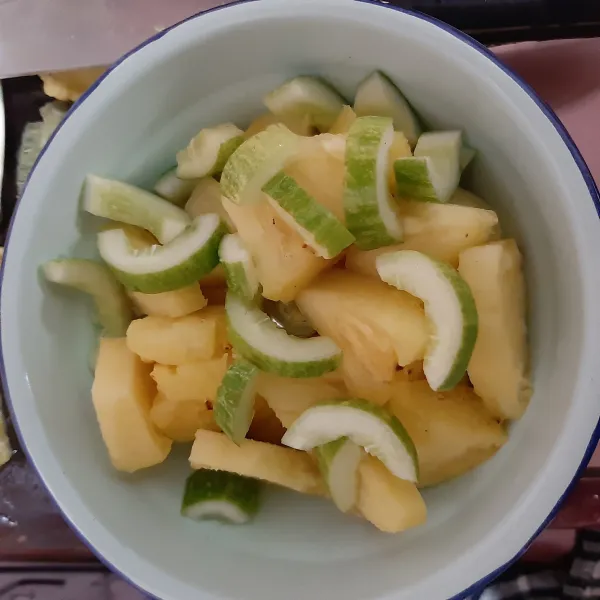 potong² pula nanas kemudian letakkan nanas dan timun dalam wadah mangkuk.