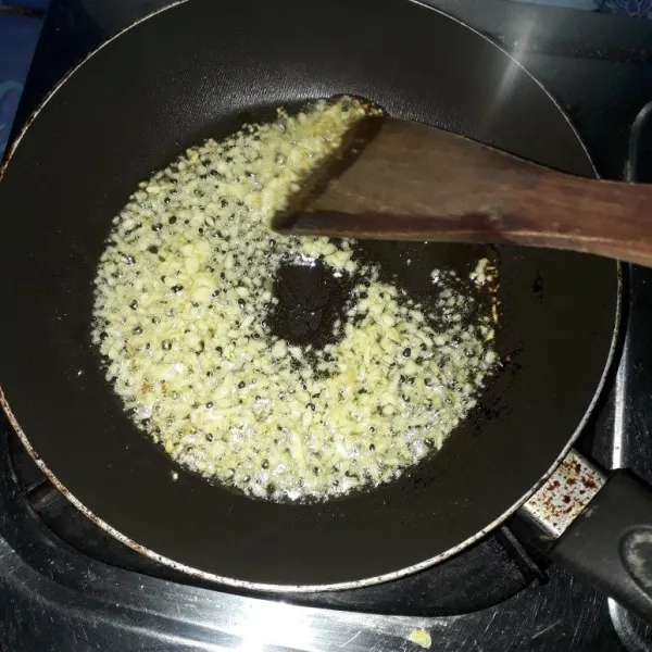 Panaskan minyak goreng, lalu tumis bawang putih cincang hingga harum.