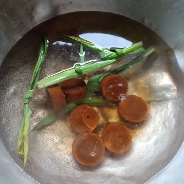 Di dalam panci, rebus air, gula merah, garam dan daun pandan sampai gula larut dan harum.
