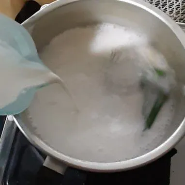 Tuang campuran tepung ke dalam rebusan santan sambil diaduk-aduk