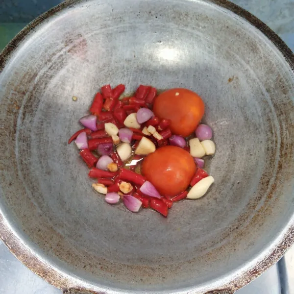 Goreng bawang merah, bawang putih, cabai merah keriting, kemiri dan tomat sampai layu.