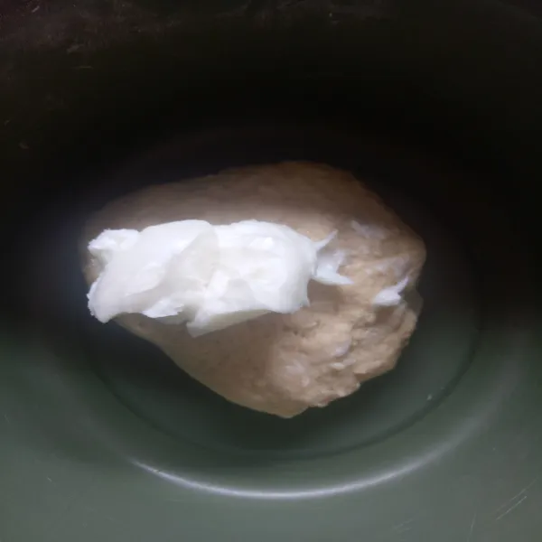 Tambahkan mentega putih, aduk hingga kalis dan diamkan selama 1 jam, ditutup dengan serbet bersih