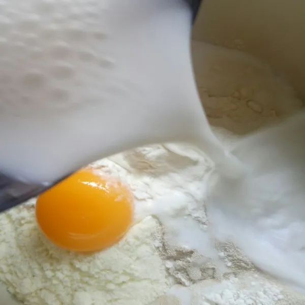 Tambahkan kuning telur dan santan, aduk hingga setengah kalis