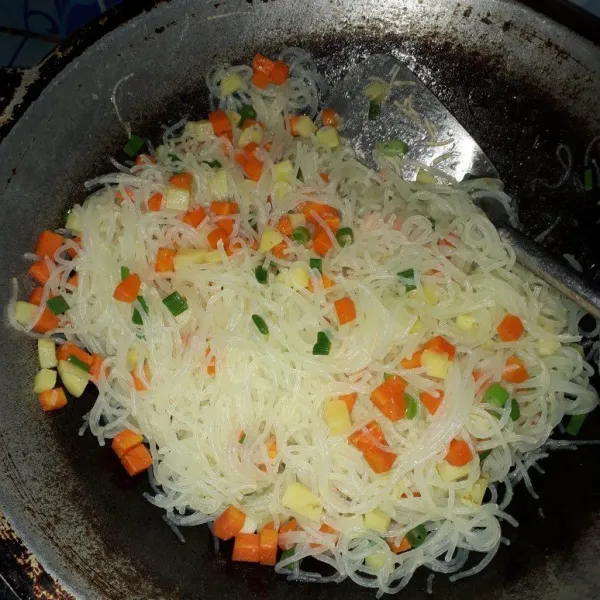 Setelah kentang dan wortel setengah matang, masukkan bihun. Masak bihun hingga matang dan tambahkan daun bawang yang telah dirajang.