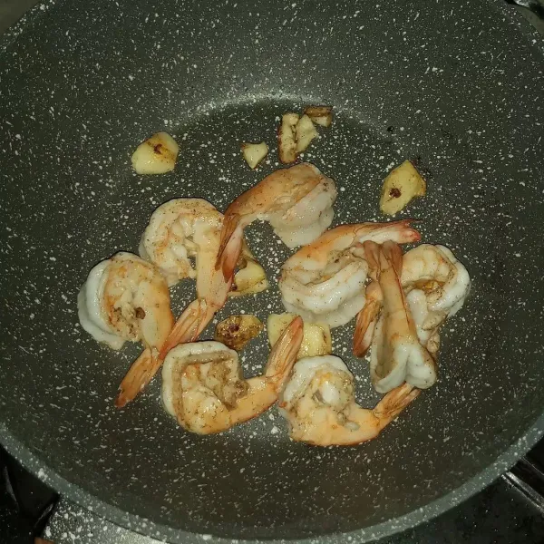 Sisakan sedikit minyak di wajan. Tumis bawang putih sampai wangi lalu masukkan udang, masak sampai berubah warna.