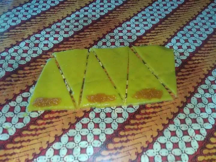 Ambil secukupnya adonan, gilas hingga pipih dan bentuk ukuran segitiga lancip 3 x 10 cm. Tambahkan secukupnya selai nanas pada tepi permukaan seperti pada gambar.