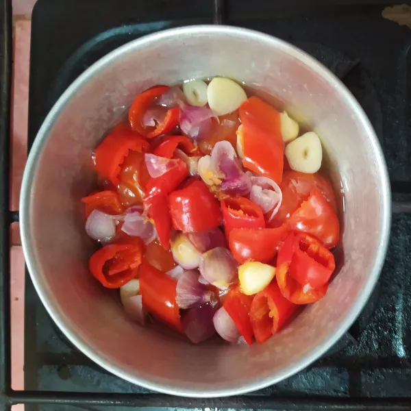 Rebus tomat, bawang merah, bawang putih dan cabe merah dengan secukupnya air sampai setengah matang.