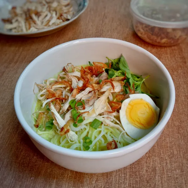 Penyajian, tata ayam suwir dan semua bahan pelengkap di dalam mangkuk, lalu siram dengan kuah laksa panas, sajikan.