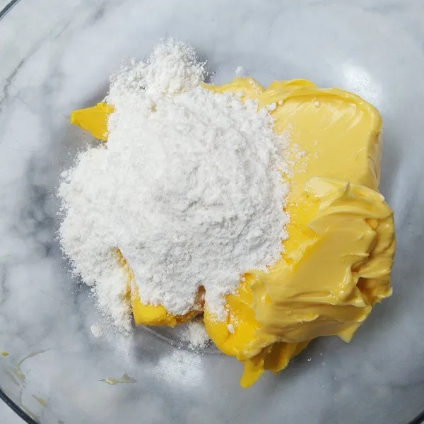 Mixer margarin, mentega, dan gula halus hingga mengembang.