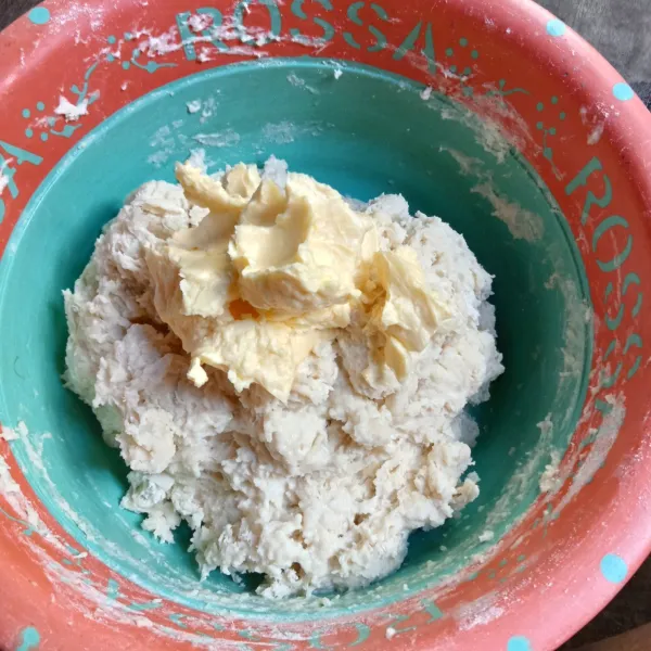 Masukkan mentega dan garam, uleni adonan hingga kalis elastis.