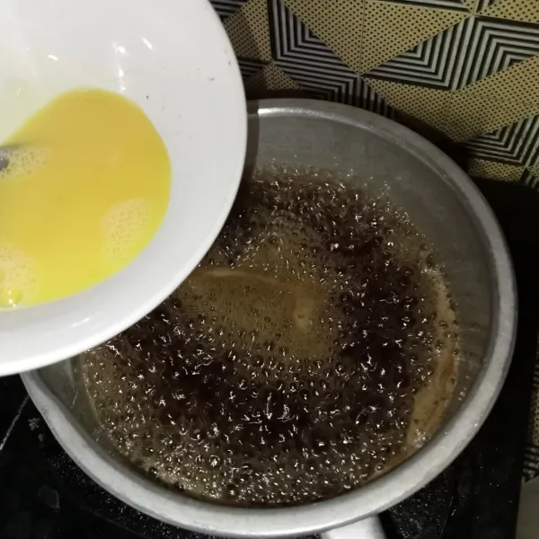Lalu masukkan telur yang sudah dikocok lepas, aduk-aduk hingga mendidih dan telur berserabut, matikan kompor.