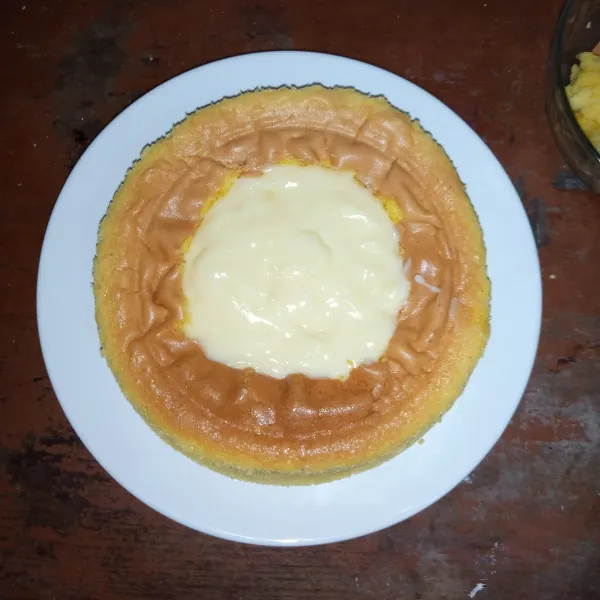 Kerok bagian tengah cake kemudian letakkan custard di dalamnya. Panggang sebentar 10 menit api atas suhu 160°C. Biarkan Custard Cake suhu ruang.