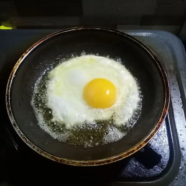 Panaskan minyak goreng. Ceplok telur, goreng sampai matang. Sisihkan.