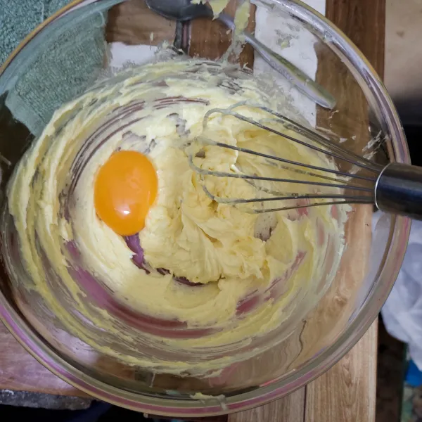 Aduk mentega dan gula halus menggunakan wisk hingga gula tercampur rata dan mentega berwarna agak putih lalu masukkan kuning telur dan aduk kembali.