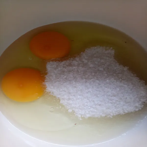 Campurkan telur dan gula pasir, aduk dengan menggunakan wiski sampai gula larut