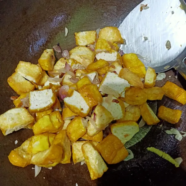 Setelah bawang merah tercium harum, masukkan tahu yang sudah digoreng, aduk rata.