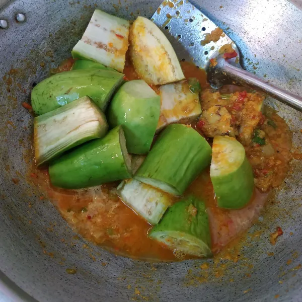 Setelah bumbu matang tambahkan air secukupnya dan masukkan terong. Masak terong sampai empuk.
