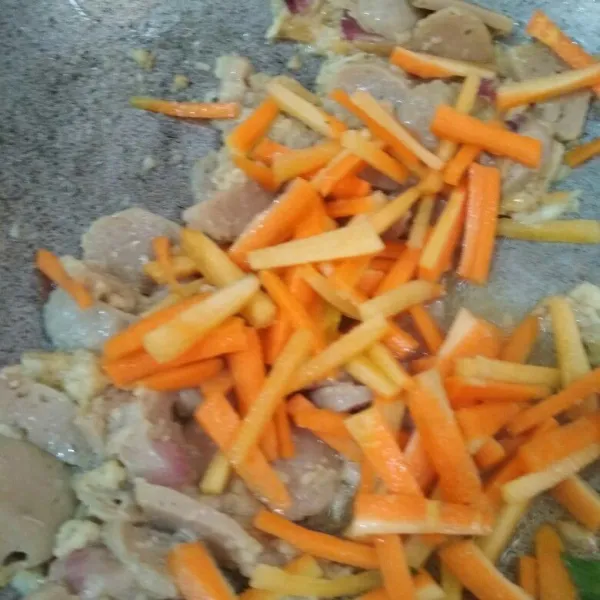 Tumis bumbu halus hingga harum tambahkan potongan bakso sapi dan potongan wortel masak hingga wortel sedikit layu.