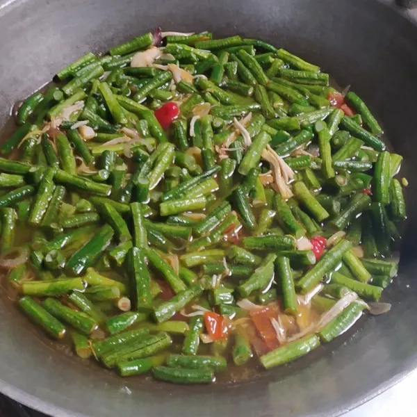 Tuangi air dan kacang panjang. Bumbui dengan garam halus, gula pasir, merica bubuk, kecap manis dan kaldu bubuk. Aduk rata.