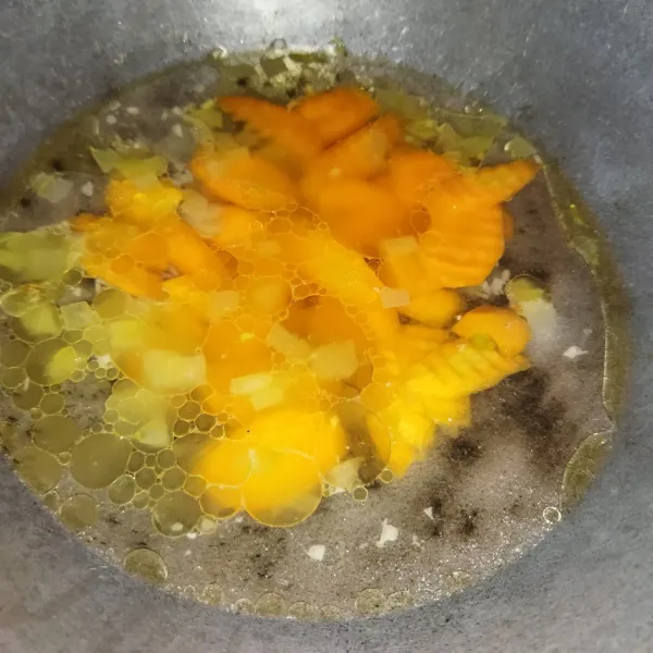 Lalu tambahkan wortel dan air, masak hingga wortel setengah matang.