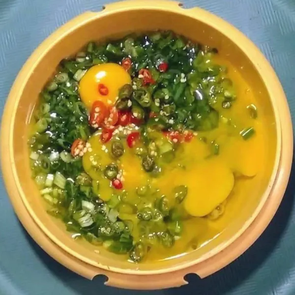 Siapkan wadah, pecahkan telur, tambahkan daun bawang, kaldu bubuk, garam dan cabe, kocok lepas sampai tercampur rata.