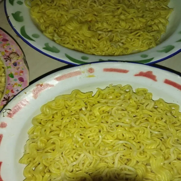 Rebus mie telur hingga matang dan jangan terlalu lembek, angkat lalu selagi panas, mie telur saya bagi di piring menjadi 3 bagian, diamkan hingga mie dingin.