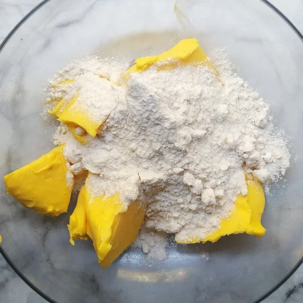 Kocok mentega dan gula halus pakai mixer kecepatan sedang sampai mengembang ringan putih ±10 menit.