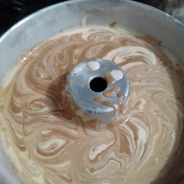 Tuang adonan ke loyang lalu campur dengan adonan yang telah dicampur dengan pasta moka, aduk rata.