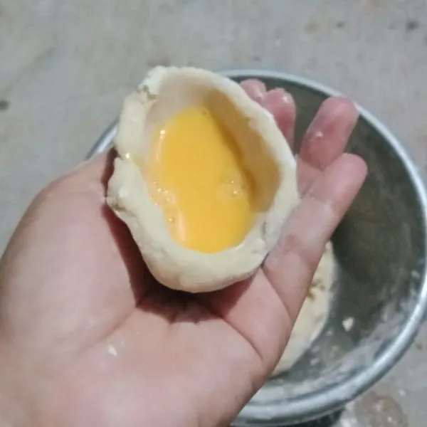 Ambil 1 genggam adonan dan buat menyerupai mangkok, isi dengan telur lalu tutup, setelah telur habis, sisanya untuk membuat lenjer