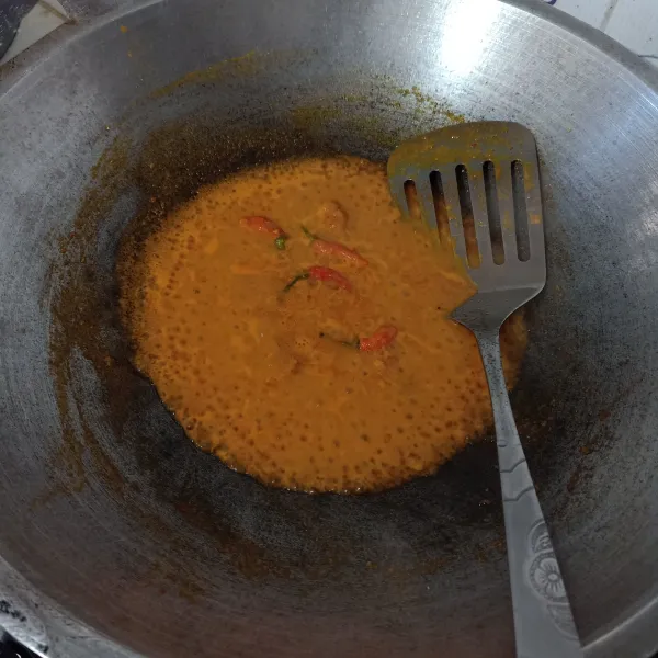Tumis bumbu halus dan rempah dengan sedikit minyak sampai harum lalu masukkan cabe rawit utuh, oseng sebentar.