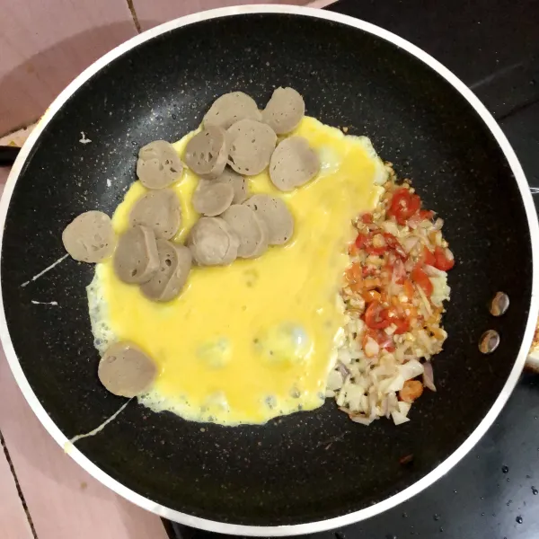 Masukkan telur kocok dan bakso, aduk rata, tunggu hingga matang