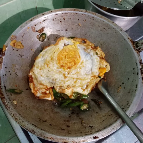 Masukkan telur ceplok, masak sampai tercampur rata dengan bumbu.