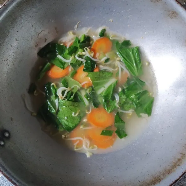 Tambahkan air rebusan ayam, masukkan bumbu-bumbu, masak hingga mendidih, koreksi rasa.