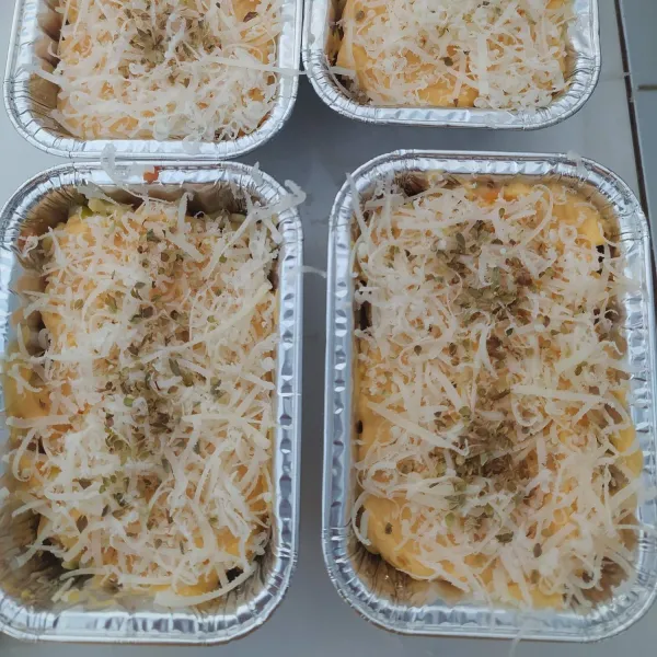 Tambahkan saos keju di atasnya, taburi dengan keju cheddar dan oregano.