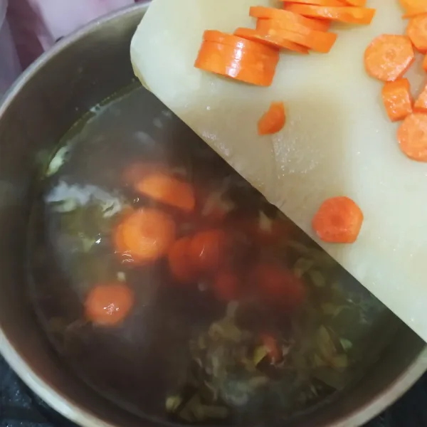 Masukkan potongan wortel. Masak sampai empuk.