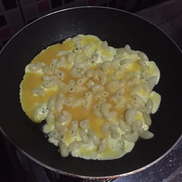 Panaskan sedikit minyak, lalu tumis sisa makaroni yang sudah direbus, tambahkan telur kocok, aduk-aduk