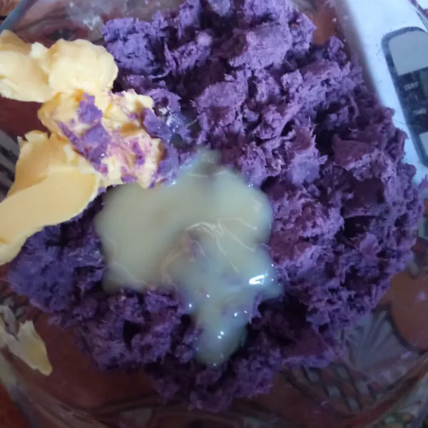 Campurkan ubi ungu dengan margarin dan SKM, aduk hingga rata dan kalis. Bagi ubi menjadi 8 bagian, lalu bentuk menjadi bulat memanjang