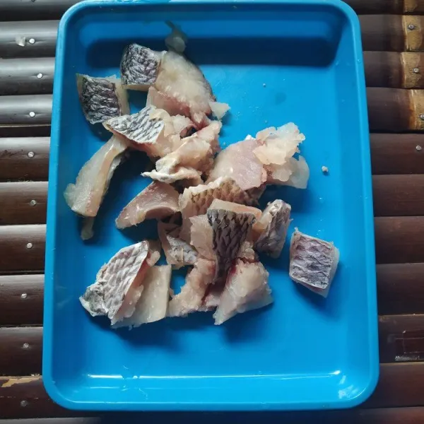 Fillet ikan nila dan potong seukuran gigitan.