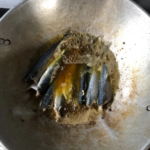 Pertama-tama bersihkan ikan buang kepala dan isi perutnya, cuci sampai bersih. Kemudian panaskan minyak dan goreng ikan layang.