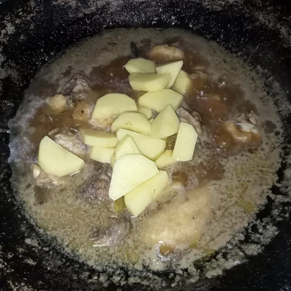 Masukkan kentang yang sudah dikupas dan dipotong, masak hingga ayam dan kentang matang.